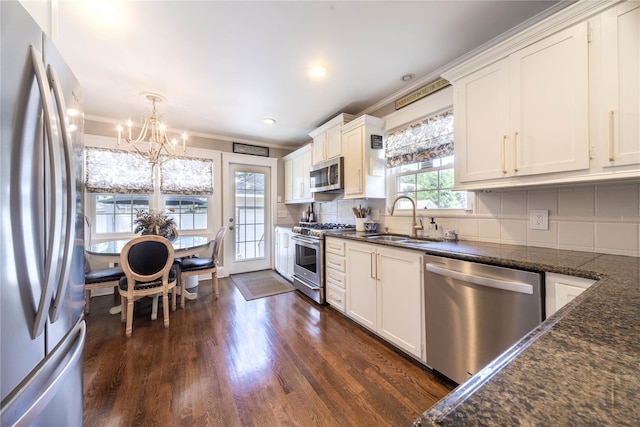 58 Hillside Ave, New Rochelle, NY 10801 - kitchen with stainless steel appliances, a chandelier, dark wood-style floors, tasteful backsplash, and white cabinetry