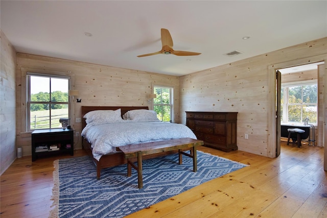 174 Sunset Trl, Clinton Corners, NY 12514 - bedroom with light wood-style flooring, wood walls, and a ceiling fan