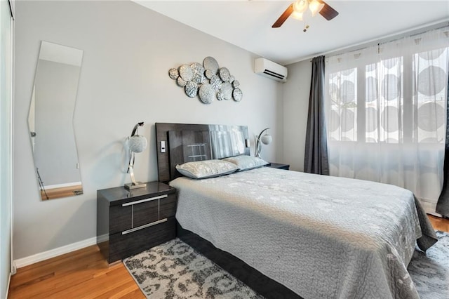 135 28th Ave Unit 2A, Brooklyn, NY 11214 - bedroom featuring an AC wall unit, wood finished floors, and a ceiling fan