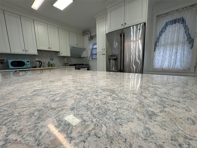 6360 102nd St Unit B19, Rego Park, NY 11374 - kitchen featuring appliances with stainless steel finishes, light stone counters, backsplash, and white cabinets