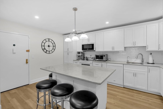 42 Richmond Blvd Unit 4B, Ronkonkoma, NY 11779 - kitchen with white appliances, a breakfast bar, light wood finished floors, white cabinets, and a center island