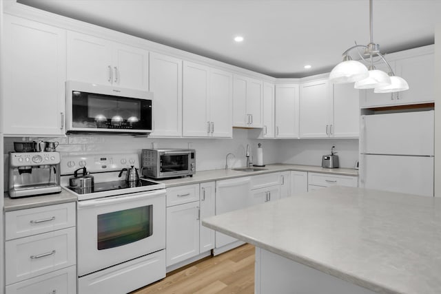 42 Richmond Blvd Unit 4B, Ronkonkoma, NY 11779 - kitchen with white appliances, light countertops, white cabinetry, light wood-type flooring, and recessed lighting