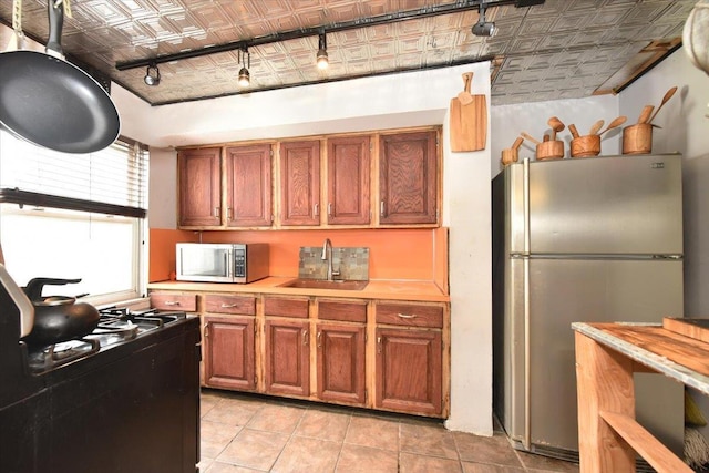 102-35 187th St, Hollis, NY 11423 - kitchen featuring an ornate ceiling, stainless steel appliances, light countertops, brown cabinetry, and light tile patterned floors