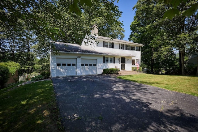 152 Bart Dr, Poughkeepsie, NY 12603 - view of front of home featuring asphalt driveway, a garage, a front lawn, and a chimney