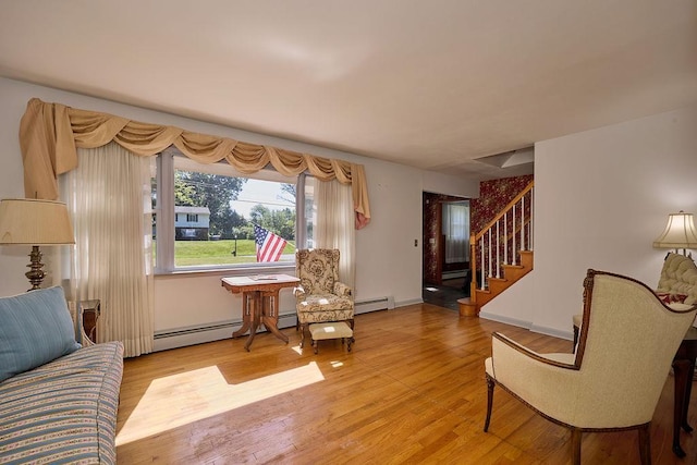 152 Bart Dr, Poughkeepsie, NY 12603 - living area featuring a baseboard heating unit, stairs, and light wood-style floors