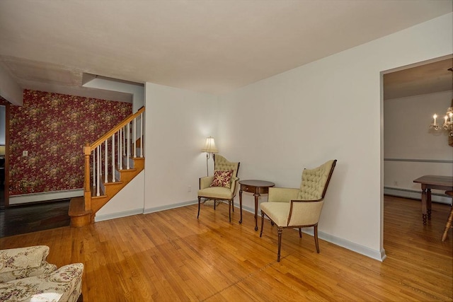 152 Bart Dr, Poughkeepsie, NY 12603 - sitting room featuring a baseboard radiator, wood finished floors, stairs, wallpapered walls, and a chandelier