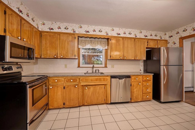 152 Bart Dr, Poughkeepsie, NY 12603 - kitchen featuring stainless steel appliances, light countertops, a baseboard radiator, brown cabinetry, and light tile patterned floors