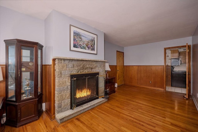 152 Bart Dr, Poughkeepsie, NY 12603 - unfurnished living room featuring wood finished floors, a wainscoted wall, and a stone fireplace