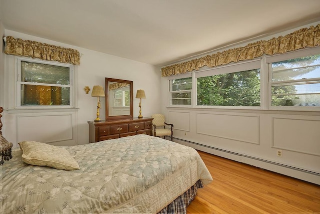152 Bart Dr, Poughkeepsie, NY 12603 - bedroom featuring a baseboard heating unit, wood finished floors, and multiple windows
