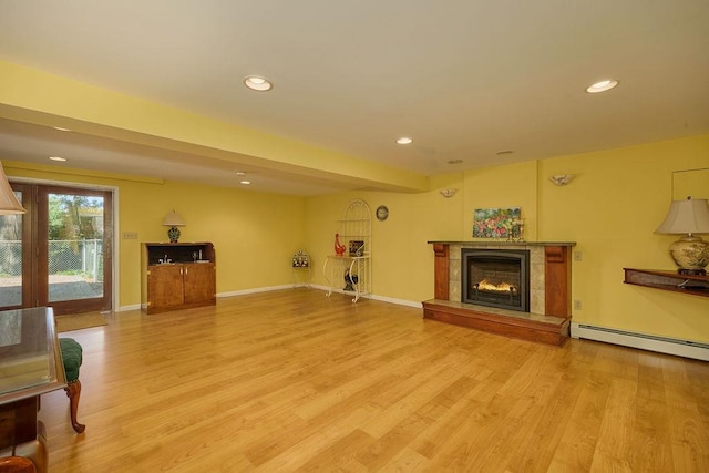 152 Bart Dr, Poughkeepsie, NY 12603 - living room featuring a lit fireplace, light wood finished floors, recessed lighting, and a baseboard heating unit