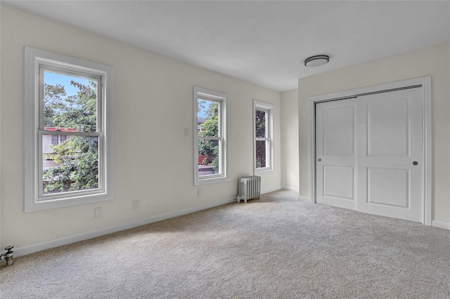 58-60 78th Ave, Glendale, NY 11385 - unfurnished bedroom with multiple windows, radiator, carpet flooring, and a closet