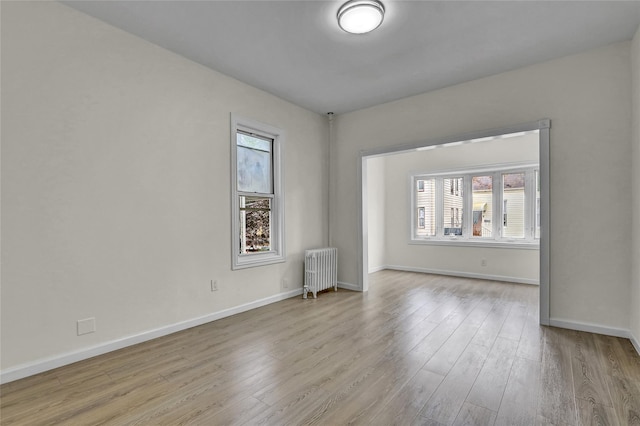 58-60 78th Ave, Glendale, NY 11385 - unfurnished room featuring radiator, healthy amount of natural light, and wood finished floors