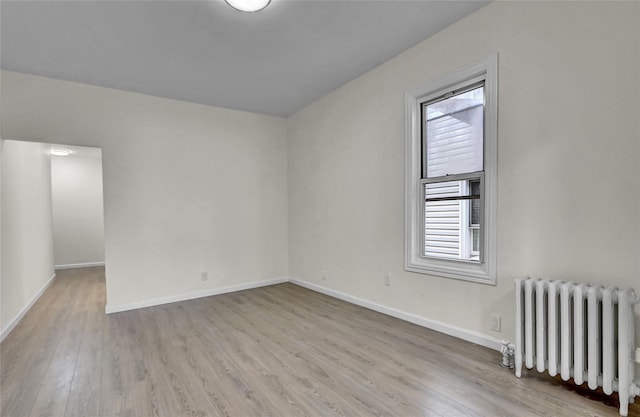 58-60 78th Ave, Glendale, NY 11385 - unfurnished room featuring radiator heating unit and wood finished floors