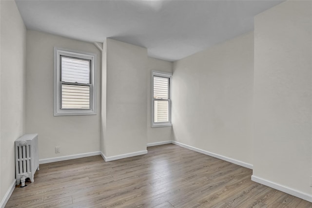58-60 78th Ave, Glendale, NY 11385 - unfurnished room featuring radiator heating unit and wood finished floors