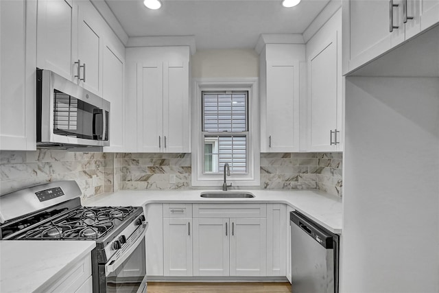58-60 78th Ave, Glendale, NY 11385 - kitchen with appliances with stainless steel finishes, white cabinets, decorative backsplash, and recessed lighting