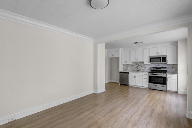 58-60 78th Ave, Glendale, NY 11385 - kitchen with stainless steel appliances, crown molding, backsplash, white cabinets, and light wood-style floors
