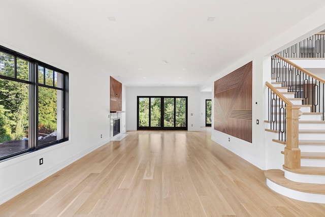 26 Saint Andrews Ct, Old Westbury, NY 11568 - unfurnished living room with light wood-type flooring, stairway, and a fireplace