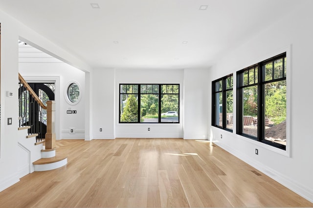 26 Saint Andrews Ct, Old Westbury, NY 11568 - unfurnished living room with light wood finished floors and stairs