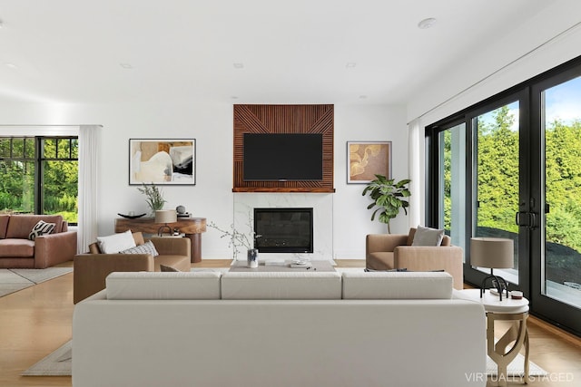 26 Saint Andrews Ct, Old Westbury, NY 11568 - living room with healthy amount of natural light, a fireplace, and wood finished floors