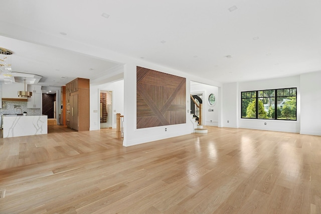 26 Saint Andrews Ct, Old Westbury, NY 11568 - unfurnished living room featuring stairs and light wood-style flooring