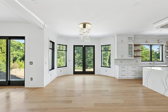 26 Saint Andrews Ct, Old Westbury, NY 11568 - kitchen with open shelves, white cabinetry, a chandelier, backsplash, and ornamental molding