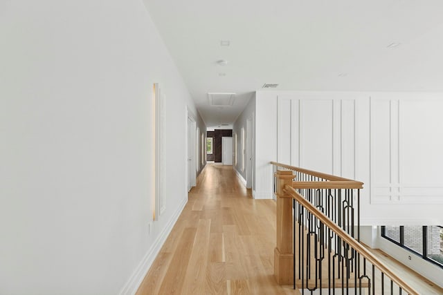 26 Saint Andrews Ct, Old Westbury, NY 11568 - hall featuring an upstairs landing, light wood-style floors, a decorative wall, and attic access