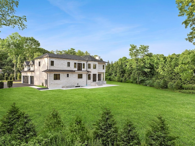 26 Saint Andrews Ct, Old Westbury, NY 11568 - rear view of house with a chimney, a lawn, a patio, and an attached garage