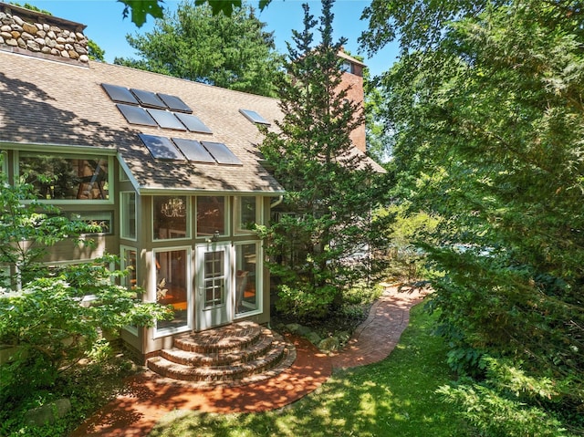880 W Mill Rd, Mattituck, NY 11952 - rear view of property with a chimney, roof with shingles, and solar panels