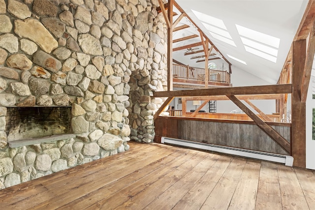 880 W Mill Rd, Mattituck, NY 11952 - unfurnished living room featuring a baseboard radiator, vaulted ceiling, a skylight, hardwood / wood-style floors, and a fireplace