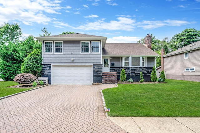 5 Pickett Ct, Malverne, NY 11565 - tri-level home with stone siding, decorative driveway, a front yard, an attached garage, and a chimney