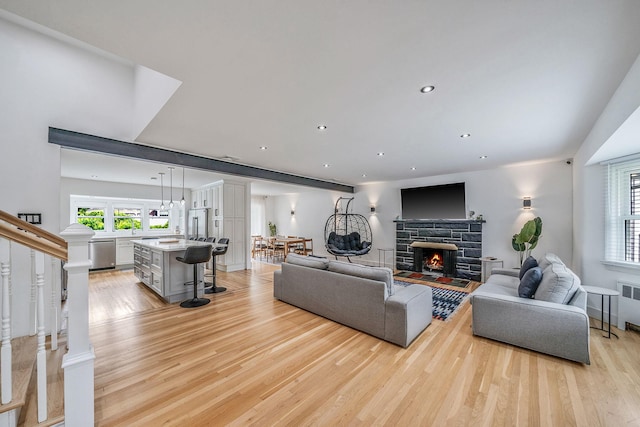 5 Pickett Ct, Malverne, NY 11565 - living area featuring light wood-type flooring, a fireplace, radiator, recessed lighting, and stairway
