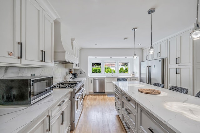 5 Pickett Ct, Malverne, NY 11565 - kitchen with high quality appliances, premium range hood, light wood-style flooring, tasteful backsplash, and white cabinets