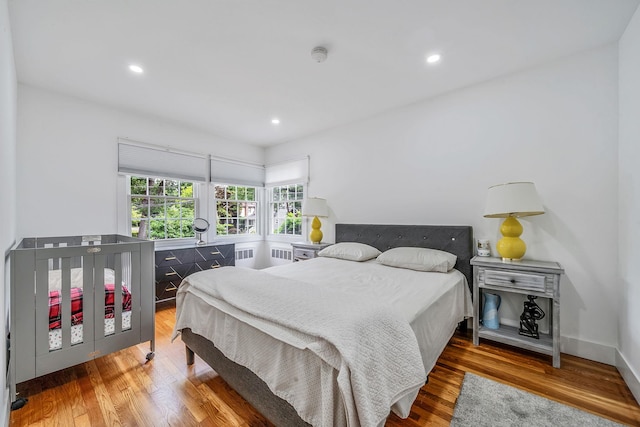 5 Pickett Ct, Malverne, NY 11565 - bedroom featuring wood finished floors, radiator, and recessed lighting