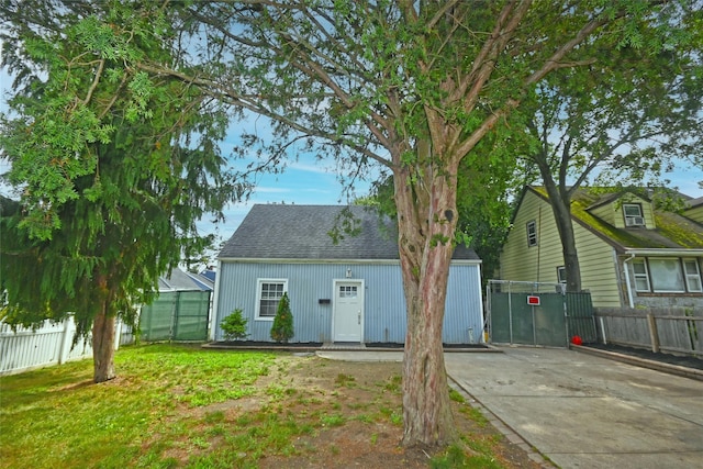 67 Maplewood Dr, Westbury, NY 11590 - back of house with an outdoor structure, driveway, and roof with shingles