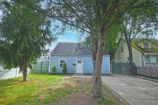 67 Maplewood Dr, Westbury, NY 11590 - rear view of house featuring an outbuilding, a shingled roof, and concrete driveway
