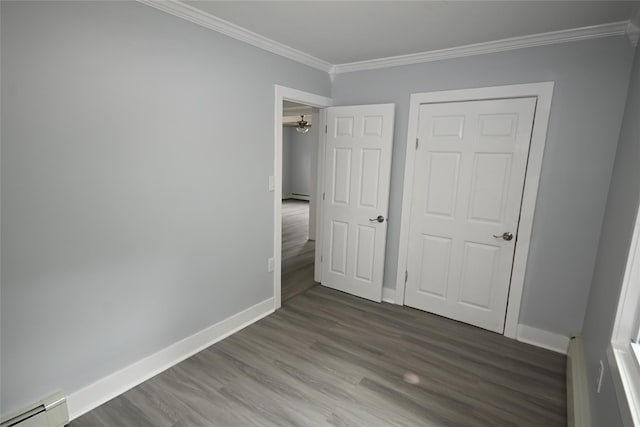 67 Maplewood Dr, Westbury, NY 11590 - unfurnished bedroom featuring a baseboard heating unit, crown molding, wood finished floors, and a baseboard radiator