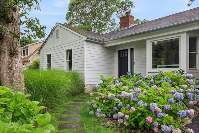 11065 Old Sound Ave, Mattituck, NY 11952 - doorway to property with board and batten siding, a chimney, and a shingled roof