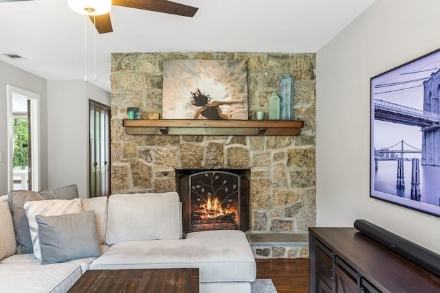 11065 Old Sound Ave, Mattituck, NY 11952 - living room with a stone fireplace, dark wood-style floors, and a ceiling fan