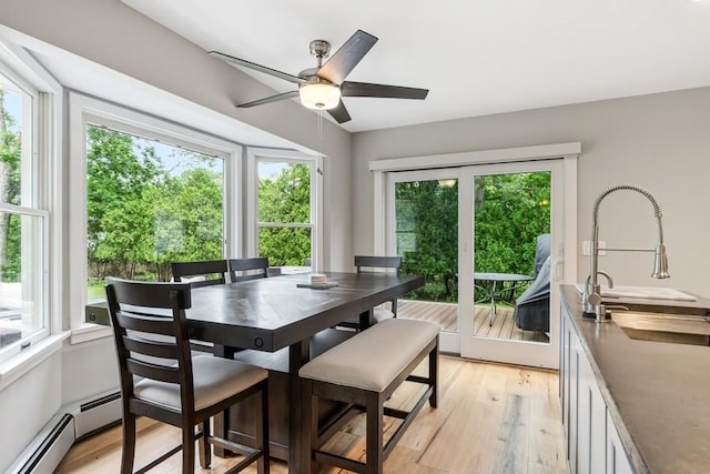 11065 Old Sound Ave, Mattituck, NY 11952 - dining space with plenty of natural light, baseboard heating, light wood-type flooring, and ceiling fan