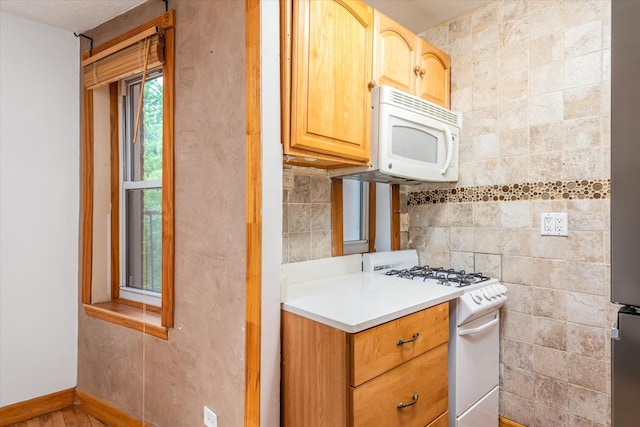 33-35 81st St Unit 4A, Jackson Heights, NY 11372 - kitchen with white appliances, light countertops, tile walls, and light brown cabinets