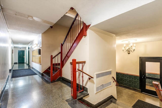 33-35 81st St Unit 4A, Jackson Heights, NY 11372 - stairway featuring heating unit, speckle patterned floor, and a chandelier