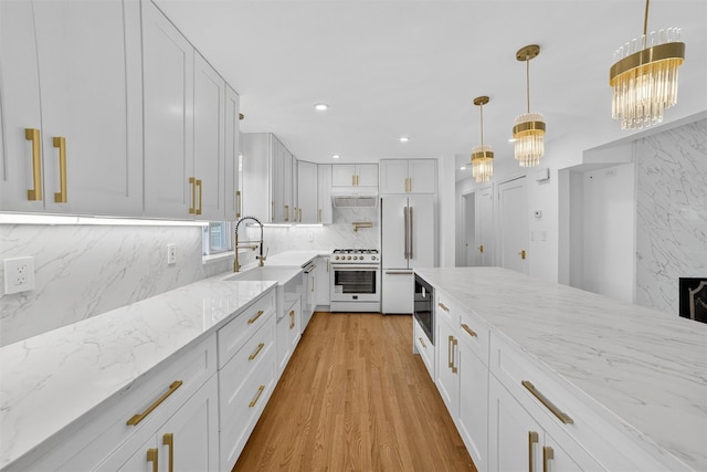 15 Benedict Ave, Eastchester, NY 10709 - kitchen featuring white appliances, light stone countertops, backsplash, light wood-style flooring, and decorative light fixtures