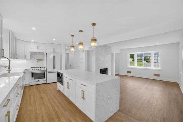 15 Benedict Ave, Eastchester, NY 10709 - kitchen featuring white appliances, light wood-type flooring, backsplash, white cabinets, and light stone counters