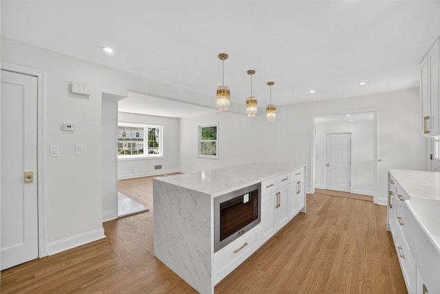 15 Benedict Ave, Eastchester, NY 10709 - kitchen with stainless steel microwave, white cabinetry, light wood-type flooring, and recessed lighting