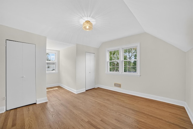 15 Benedict Ave, Eastchester, NY 10709 - unfurnished bedroom with multiple windows, light wood-style floors, lofted ceiling, and two closets
