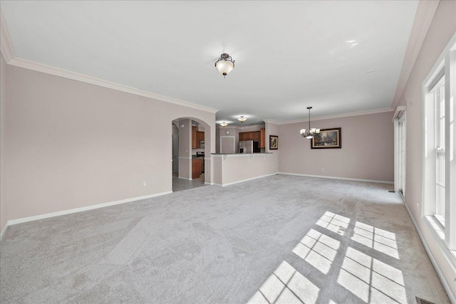 13 Nicole Ct, Copiague, NY 11726 - unfurnished living room featuring arched walkways, a chandelier, light carpet, ornamental molding, and healthy amount of natural light