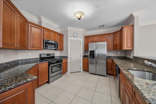 13 Nicole Ct, Copiague, NY 11726 - kitchen featuring stainless steel appliances, ornamental molding, brown cabinets, dark stone countertops, and light tile patterned floors