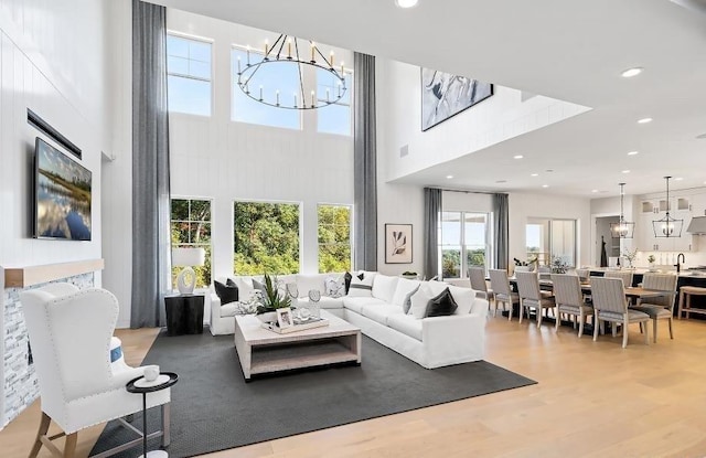 22 Sienna Ct, Dix Hills, NY 11746 - living room with a chandelier, a high ceiling, recessed lighting, and light wood-type flooring