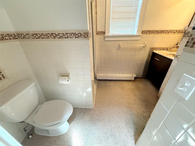 1144 N Ave, New Rochelle, NY 10804 - bathroom with tile walls, tile patterned floors, vanity, a baseboard radiator, and wainscoting