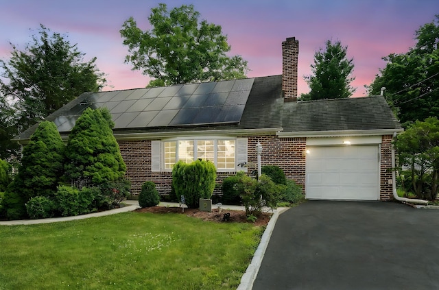 2 Ann Pl, Valhalla, NY 10595 - cape cod home with an attached garage, brick siding, solar panels, and asphalt driveway